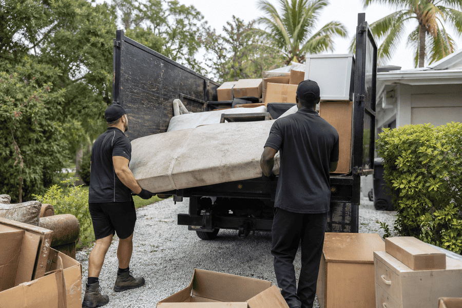 Furniture and junk being loaded into a haul-away truck